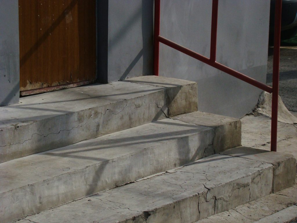 a cat sitting on the steps of a building